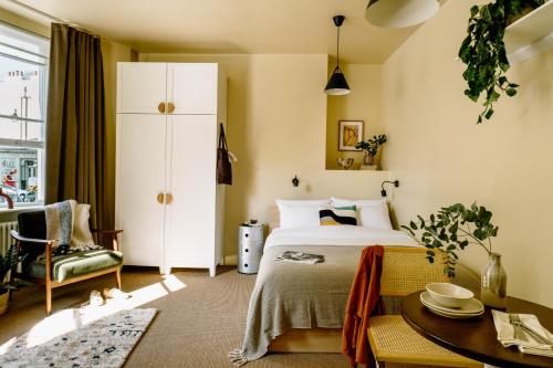 伦敦Mason & Fifth, Primrose Hill的卧室配有1张床、1张桌子和1把椅子