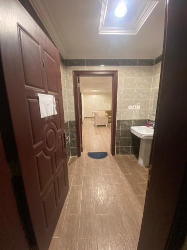 Ḑubāغرفة مع دورة مياه 201的浴室设有门、卫生间和水槽。
