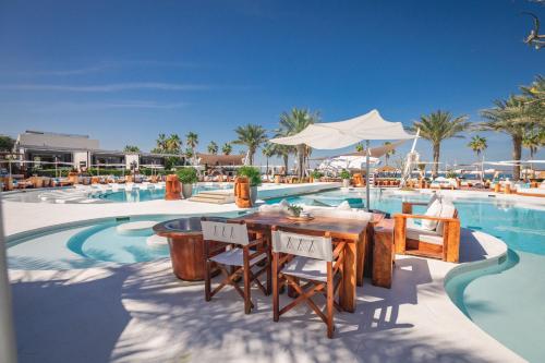 迪拜迪拜尼基海滩度假村及Spa的一个带桌椅的游泳池的度假酒店