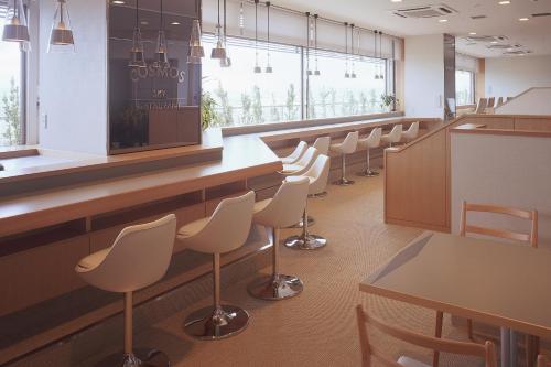 横手市Hotel Plaza Annex Yokote的一间设有白色椅子和酒吧的等候室