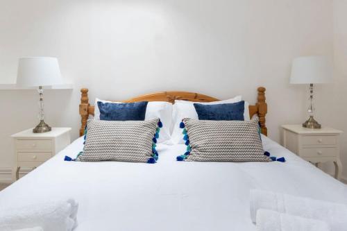 奥克姆Independence House的一张带蓝色枕头的白色床和两盏灯。
