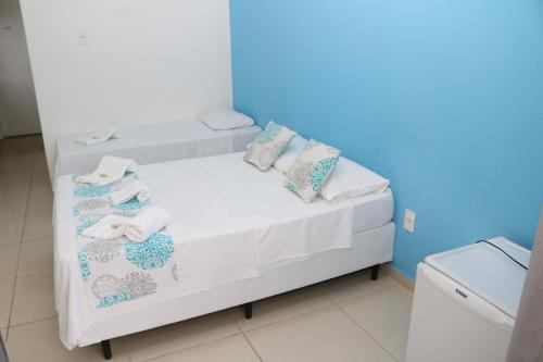 曼加拉蒂巴Pousada Lisamar的一张带枕头和毛巾的白色床