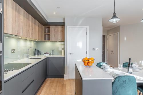 雷丁Bond House by Celador Apartments的厨房配有白色的柜台和木制橱柜。