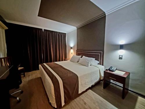 康塞普西翁埃尔阿拉乌卡诺酒店的酒店客房配有一张床铺和一张桌子。