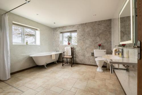 彻奇斯特雷顿Pendennis at Eaton Manor的带浴缸、卫生间和盥洗盆的浴室