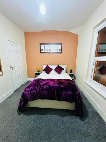 利物浦Elm Vale Lodge的一间卧室配有一张带紫色毯子的床