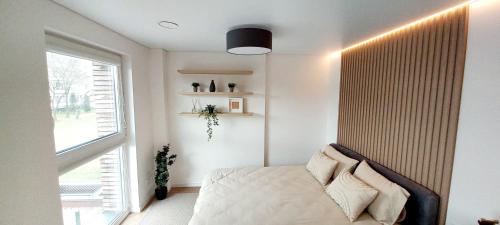 考纳斯Hygge Apartment in Silainiai, Kaunas的一间卧室设有一张床和一个大窗户