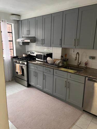 Rego ParkStay Rego Park的厨房配有灰色橱柜和水槽