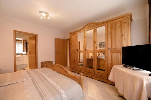 克罗夫Haus Beate Klein的一间卧室配有一张床和一个大型木制橱柜