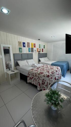 若昂佩索阿Israel flat tambau 106的酒店客房设有两张床和一张桌子。