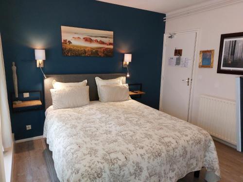 富伦王头餐厅酒店的一间卧室配有一张带蓝色墙壁的大床