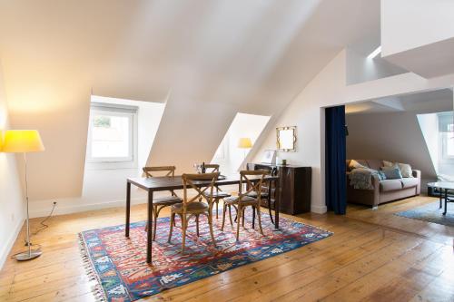 里斯本巴尔罗奥托阁楼公寓的一间位于地毯上的带桌椅的用餐室