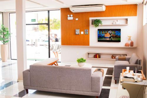 巴纳伊巴Citi Executivo Hotel的带沙发和电视的客厅