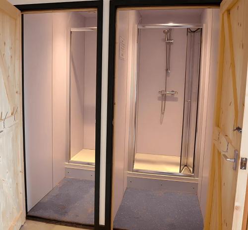 比迪福德Adventure Lodges and Retreats的浴室设有玻璃门和步入式淋浴间