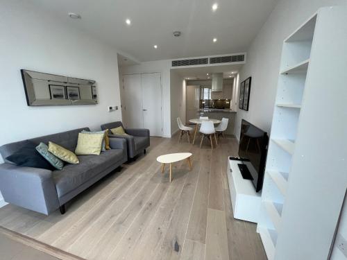 伦敦1 Bedroom Apartment Stratford的客厅配有沙发和桌子