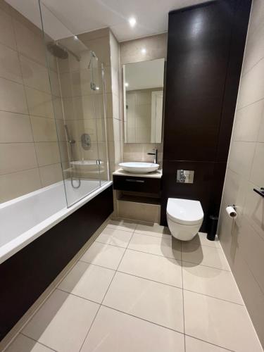 伦敦1 Bedroom Apartment Stratford的浴室配有卫生间、盥洗盆和淋浴。