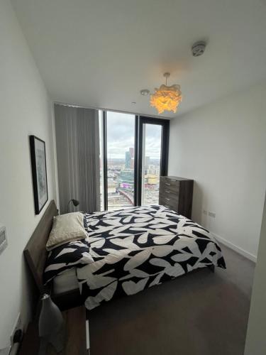 伦敦1 Bedroom Apartment Stratford的卧室配有一张黑白床和窗户