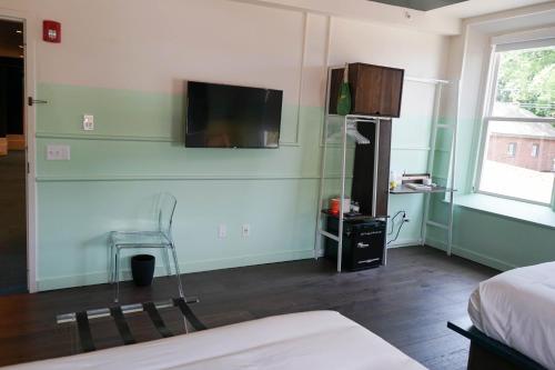 纳什维尔The Russell的卧室设有壁挂式电视和床。