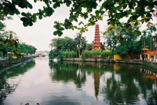 河内Homestay - Kim Mã - Giang Văn Minh的享有河流的景色,塔楼为背景