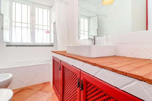 埃尔瓦斯Monte da Vista Alegre的一间带白色水槽和红色橱柜的浴室