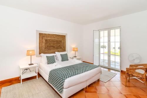 埃尔瓦斯Monte da Vista Alegre的白色的卧室设有床和窗户