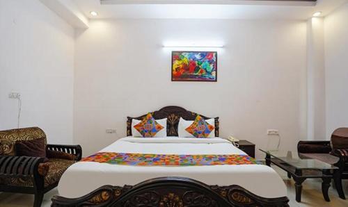 诺伊达FabHotel Noida Sector 50的一间卧室配有一张大床和两把椅子