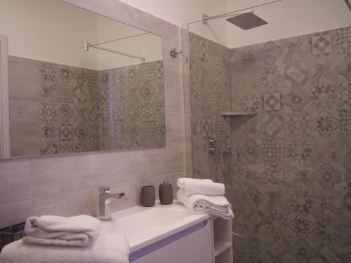 菲乌米奇诺Our Guest House的浴室配有盥洗盆和带镜子的淋浴