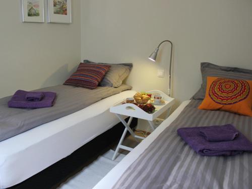雷克雅未克GP Apartment的一间卧室配有两张床和一张带紫色毛巾的边桌