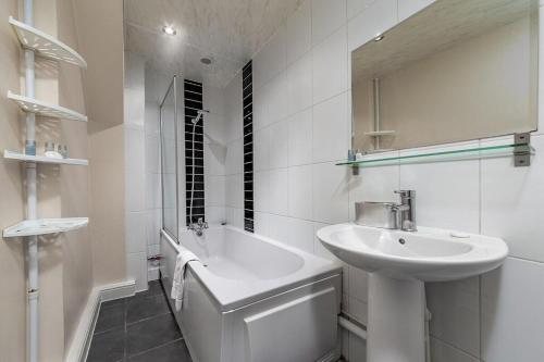 伦敦The Mount的白色的浴室设有水槽和浴缸。
