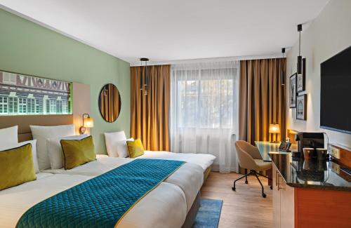 埃斯林根Leonardo Hotel Esslingen的酒店客房设有一张大床和一张书桌。