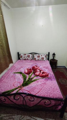 马拉喀什Appartement situé à 5 minutes à pied de l'Aeroport de Marrakech的粉红色的床,上面有一束玫瑰