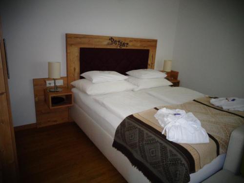 林区圣雅各布Familienhotel Berger的一间卧室配有两张床、白色的床单和毛巾。