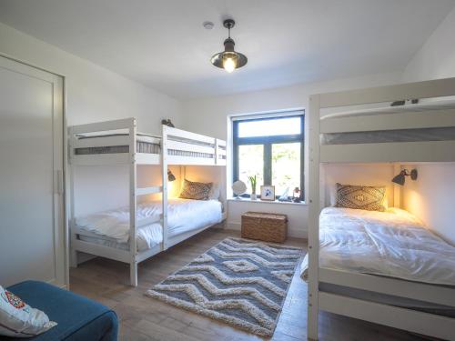 PenbrynTy Machlud Tresaith的卧室配有两张双层床和地毯。