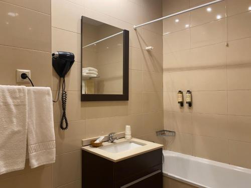 蒙考Hotel Dom Afonso - Monção的浴室配有盥洗盆、镜子和浴缸