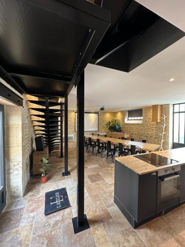 贝叶L'ATELIER DU VIEUX BOIS Spa的开放式厨房和带长桌的用餐室
