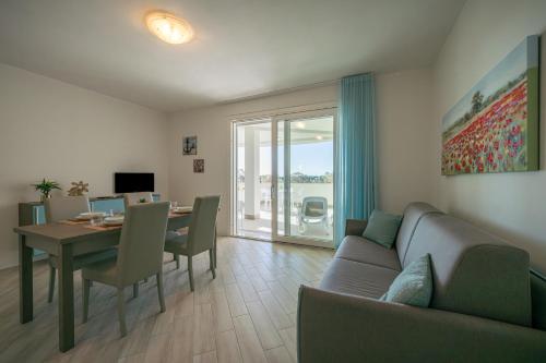 阿尔盖罗Milena Suite Apartments的一间带桌子和沙发的客厅以及一间用餐室