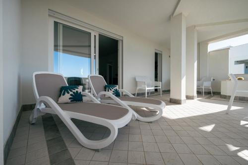 阿尔盖罗Milena Suite Apartments的一组椅子坐在阳台上