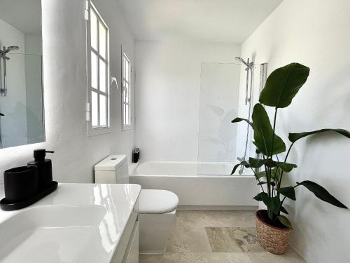 马贝拉4 bedroom Villa in Top location - Heating Pool的浴室配有白色浴缸、卫生间和植物
