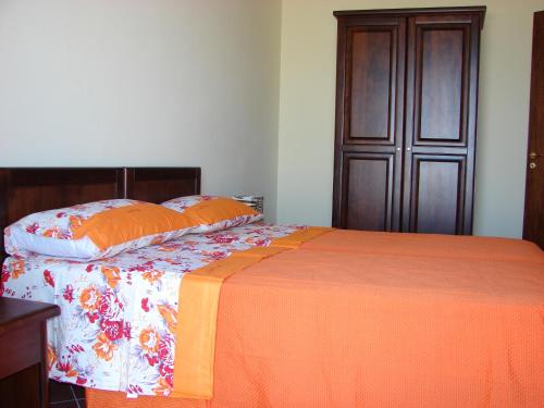 FilandariBorgo Nicoletta Case per le vacanze的一张带橙色毯子和枕头的床