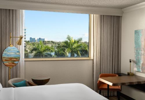 普兰塔寻Renaissance Fort Lauderdale West Hotel的酒店客房设有一张床和一个大窗户