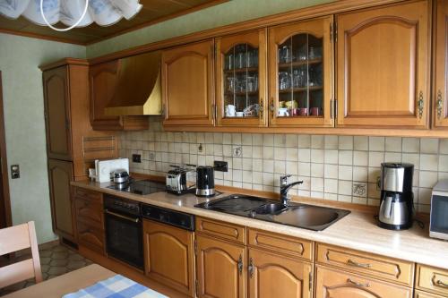 HohenleimbachFewo Adams的一个带木制橱柜和水槽的厨房