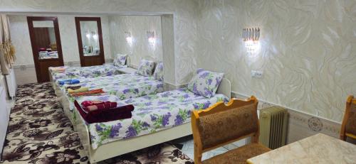 撒马尔罕HOTEL-129的一间设有两张床和一张桌子及椅子的房间