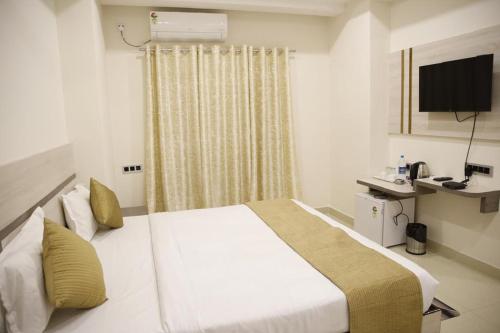 古瓦哈提Hotel- The Yellow Queen的酒店客房,配有床和电视