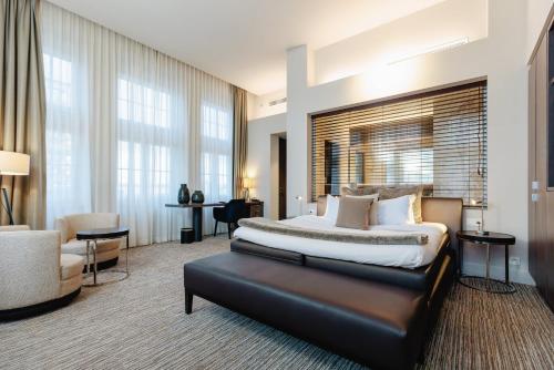 马斯梅赫伦特海尔斯酒店的一间卧室配有一张特大号床和一把椅子