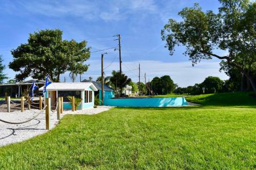 萨拉索塔Pinecraft Sunset Tiny Home的一座公园,里面设有蓝色的建筑和一个游乐场