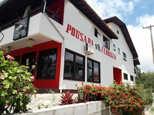 加罗帕巴Pousada Via Ferrugem的拥有红色和白色外墙的建筑