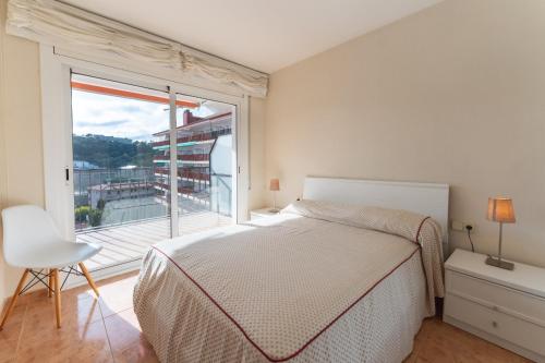 滨海托萨Apartamento Pau Picasso con terraza Tossa de Mar的一间卧室设有一张床和一个大窗户