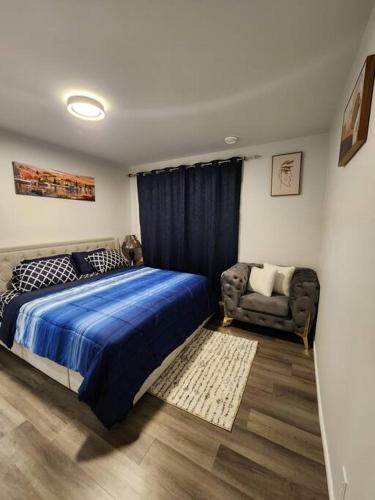 艾尔德里Cozy one bedroom in Airdrie的一间卧室配有蓝色的床和椅子