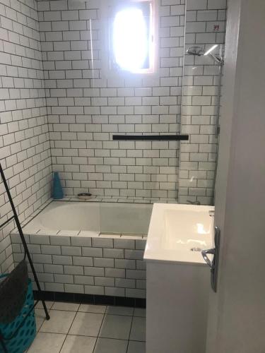 乌瑞基尼vacances的白色的浴室设有浴缸和水槽。