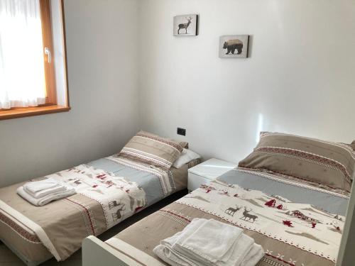 摩德纳迪-坎皮格里奥Adamello Brenta Sunshine的一间卧室设有两张床和窗户。